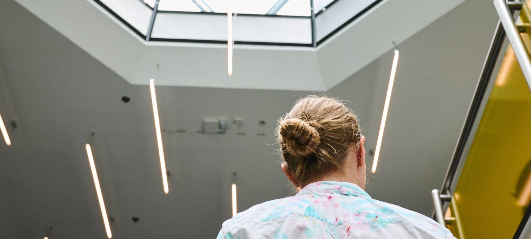 Eine Frau geht in einem Bürohaus eine Treppe hoch