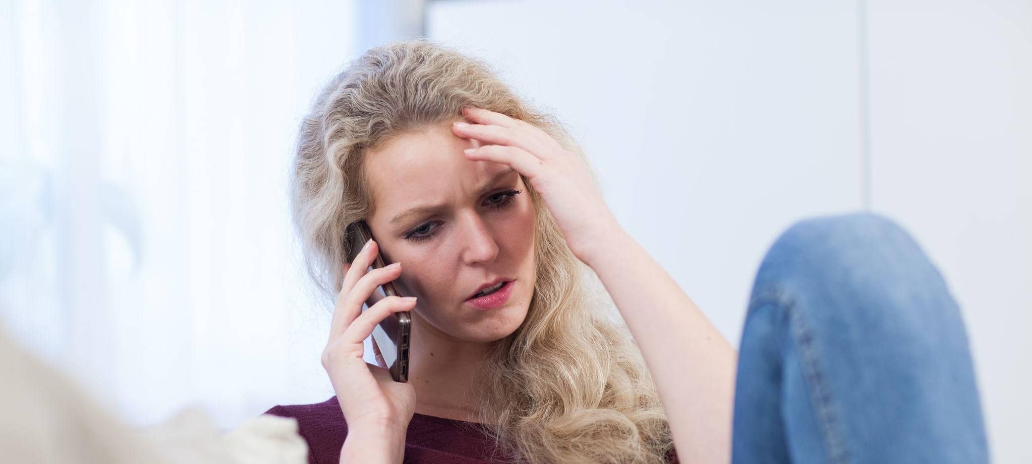 Eine Frau telefoniert besorgt mit dem Handy